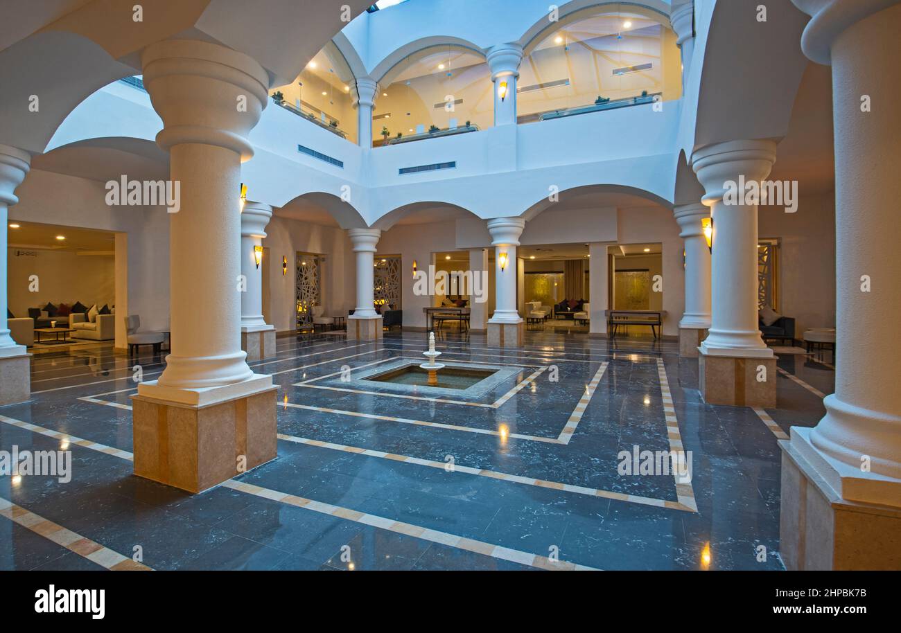Interior design of a luxury hotel resort lobby reception area with seating and columns Stock
