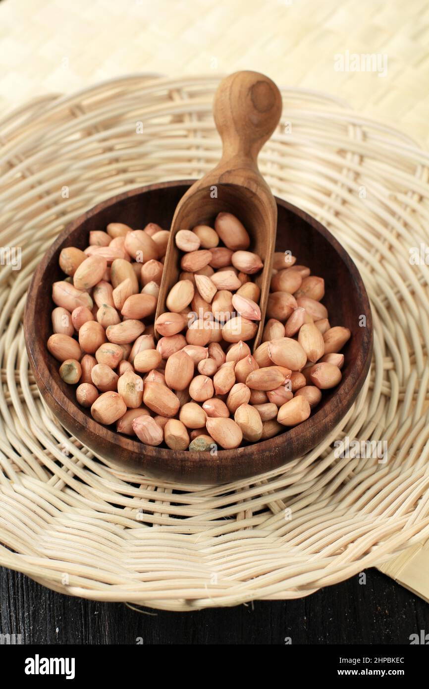 Raw Peanuts on Wooden Bowl with Wooden Scoop Stock Photo