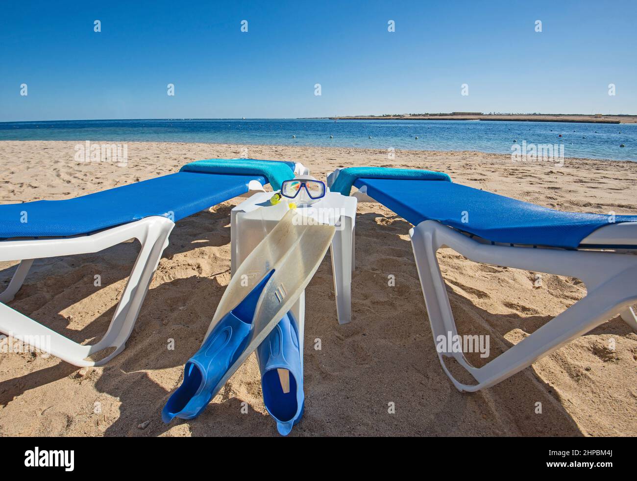 Landscape view over ocean at tropical hotel resort beach with sun loungers and snorkeling equipment Stock Photo