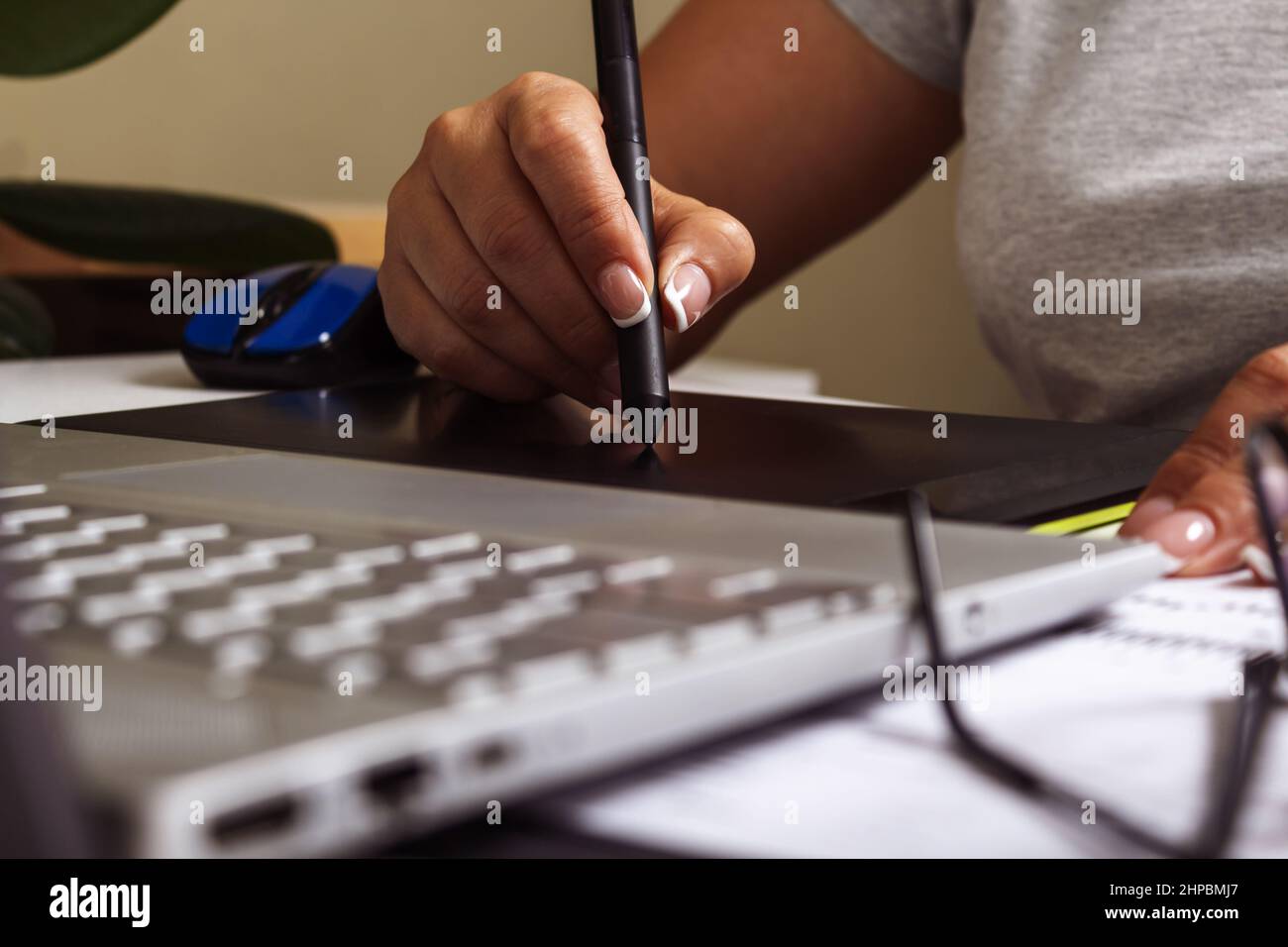 Woman working on graphics tablet with stylus.  Stock Photo
