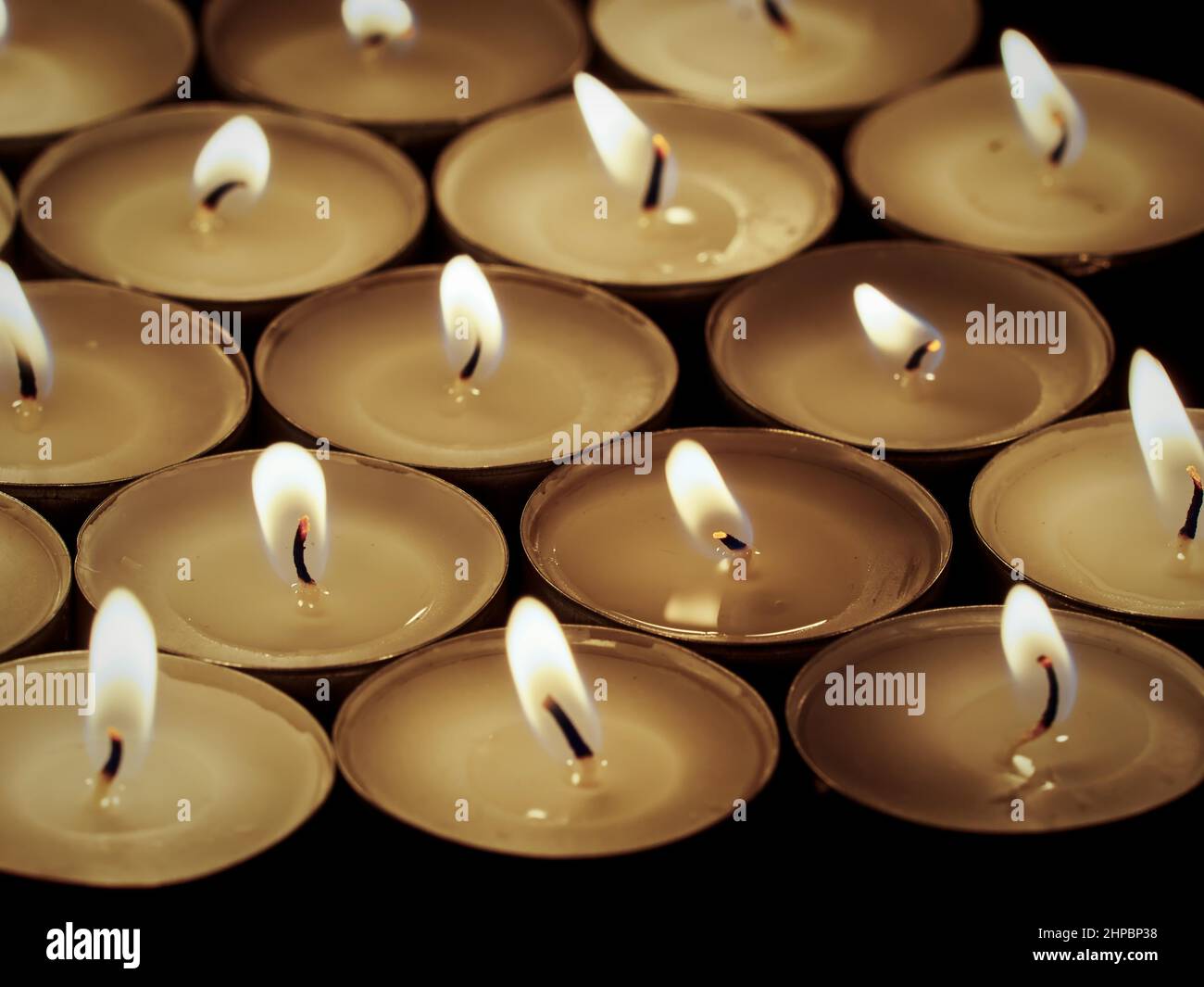 Tealight candles burning on a black background. Concept of death, loss and mourning Stock Photo