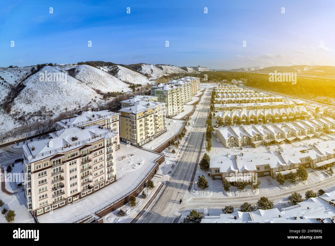 Russia, Krasnoyarsk, February 19, 2022: New residential complex incom pines, elite residential area, houses and townhouses on the riverbank at the foo Stock Photo