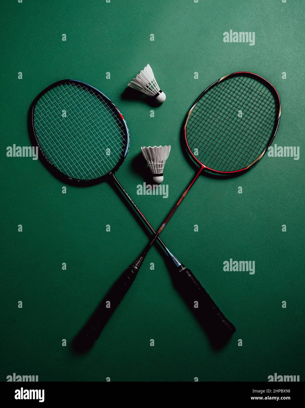 Pair of racket and two birdies on a green badminton court Stock Photo ...