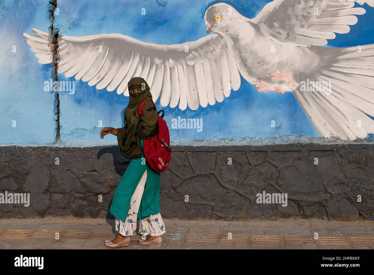 New Delhi, New Delhi, India. 20th Feb, 2022. Hijab-wearing Muslim girl reacts as she walks past graffiti on a street. (Credit Image: © Karma Sonam Bhutia/ZUMA Press Wire) Stock Photo