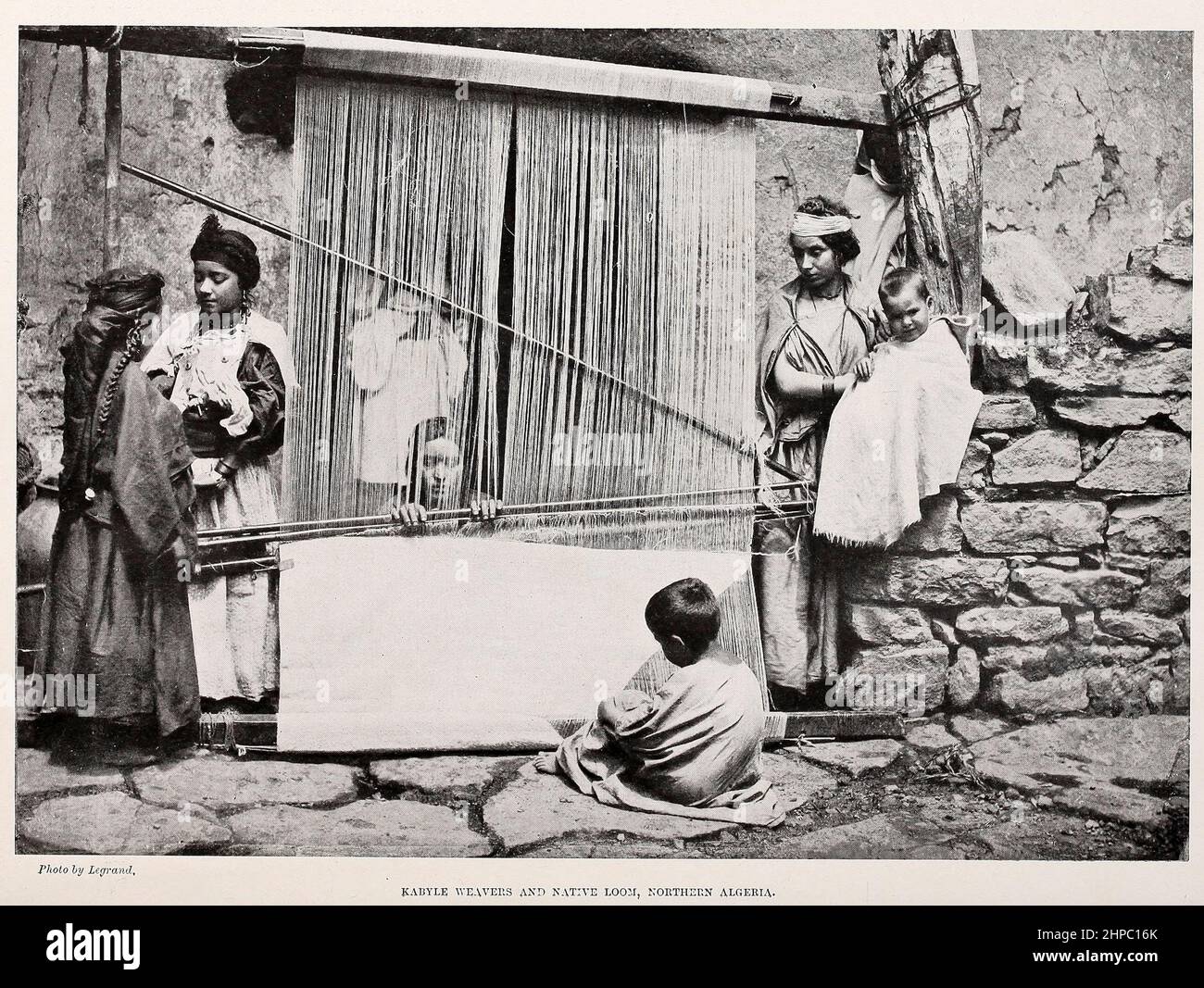 Kabyle Weavers and Native Loom, Northern Algeria from the book ' The living races of mankind ' a popular illustrated account of the customs, habits, pursuits, feasts & ceremonies of the races of mankind throughout the world by Sir Harry Hamilton Johnston, and Henry Neville Hutchinson Published in London by Hutchinson & Co. in 1902 Stock Photo