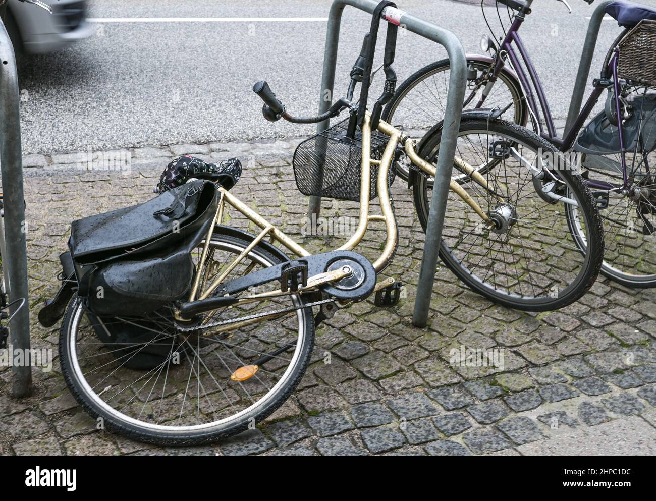 Overturned bicycle chained to a public stand on the street in the city, Germany, selected focus Stock Photo