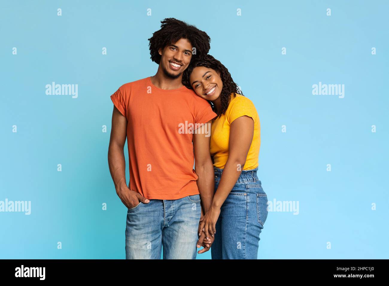 Happy african american couple posing on blue, holding hands Stock Photo ...
