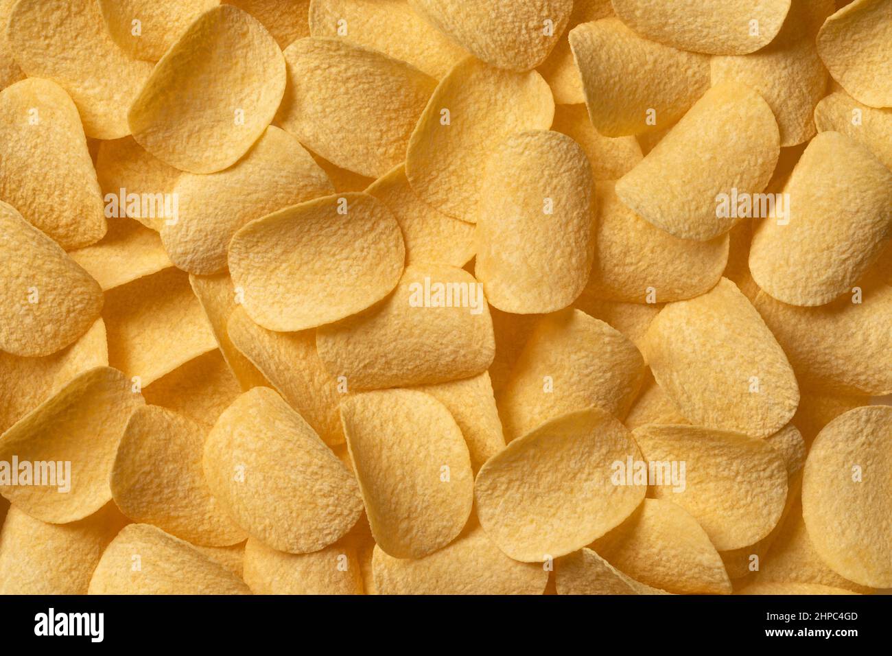 Deep fried crunchy potato chips close up full frame as background Stock Photo