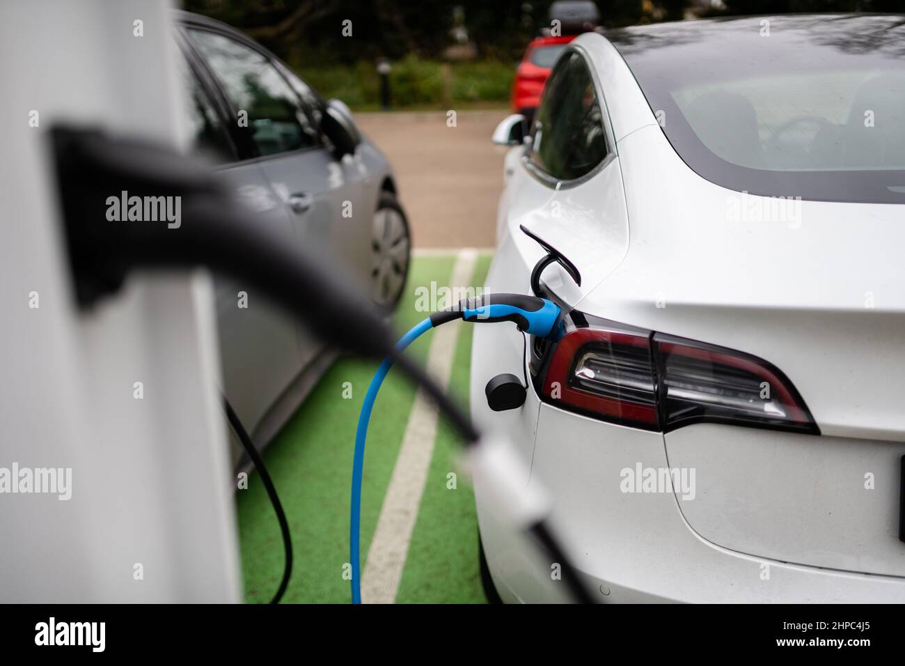 Electric cars charging at plug in charge station in a public car park