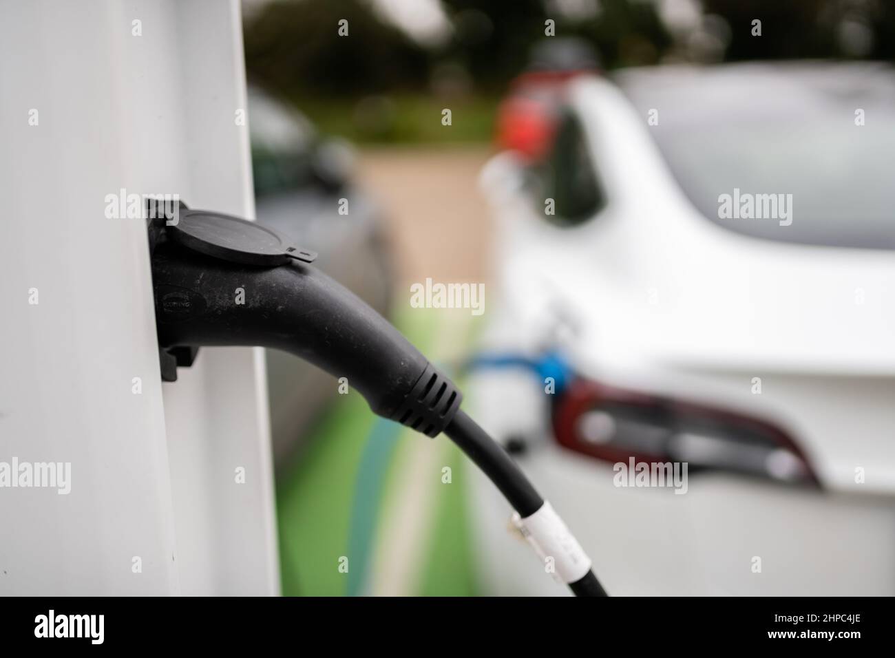 Electric cars charging at plug in charge station in a public car park