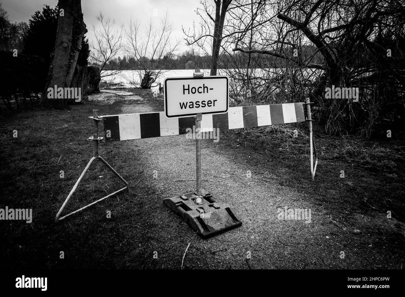 on a flooded path there is a sign with the inscription Flooding Stock Photo