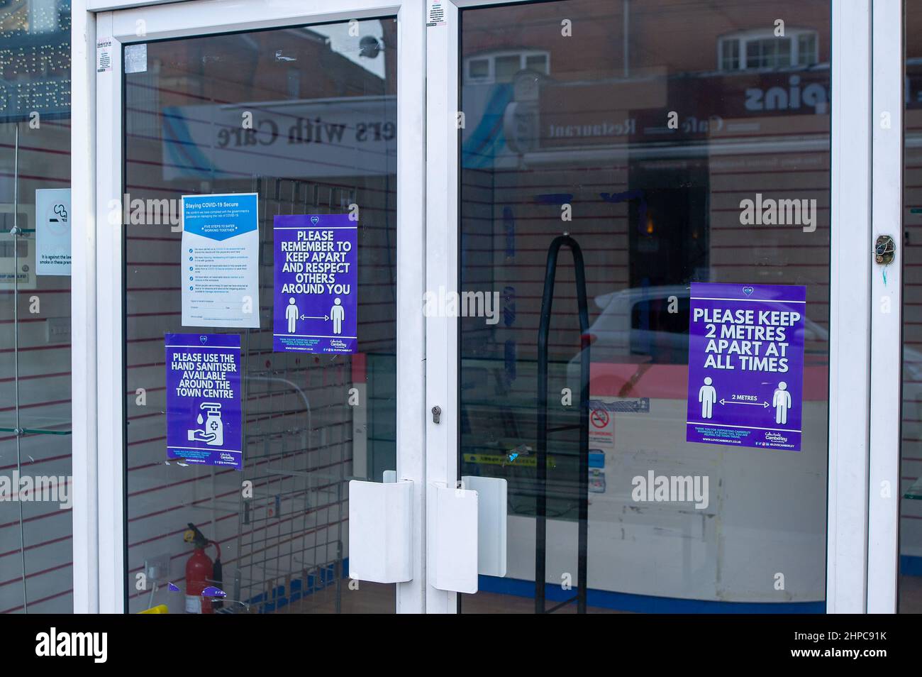 Camberley, Surrey, UK. 10th February, 2022. Covid-19 signs in the window of a closed down shop in Camberley. Many businesses have gone to the wall during the Covid-19 Pandemic. Credit: Maureen McLean/Alamy Stock Photo