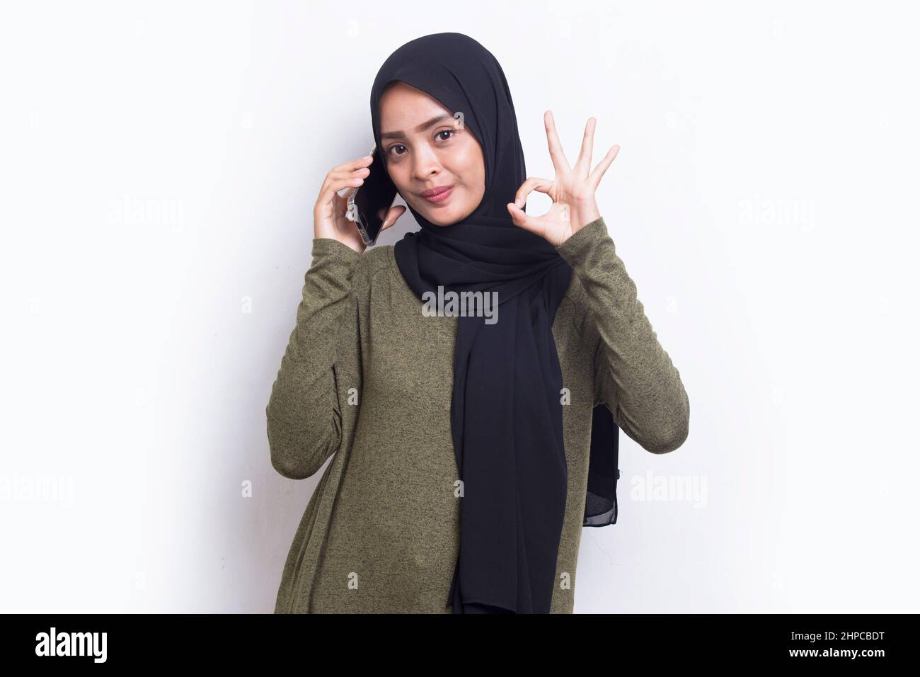 happy young asian beautiful muslim woman using mobile phone isolated on ...