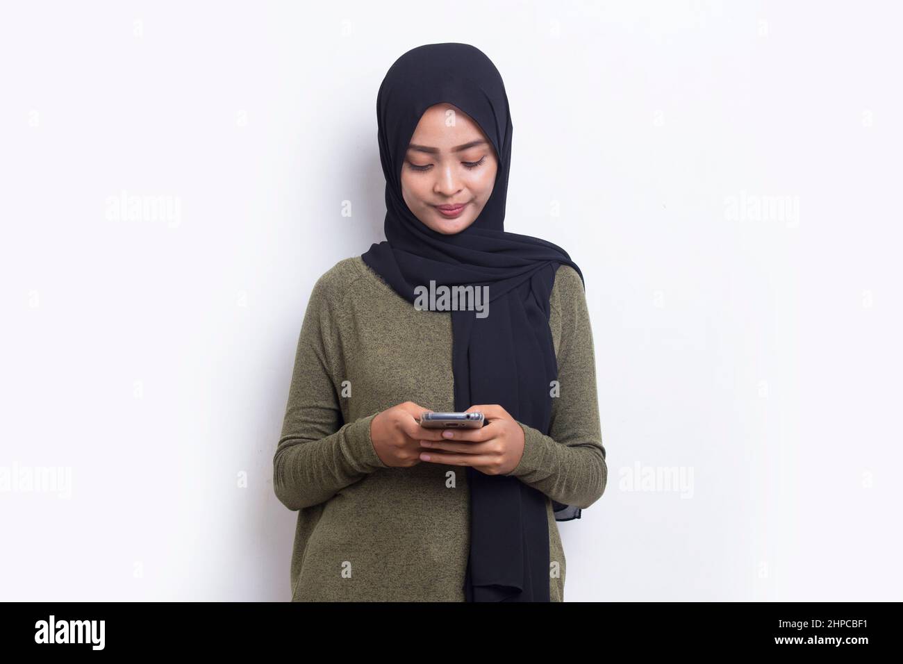 happy young asian beautiful muslim woman using mobile phone isolated on ...