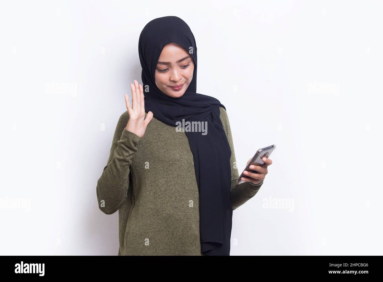 happy young asian beautiful muslim woman using mobile phone isolated on ...