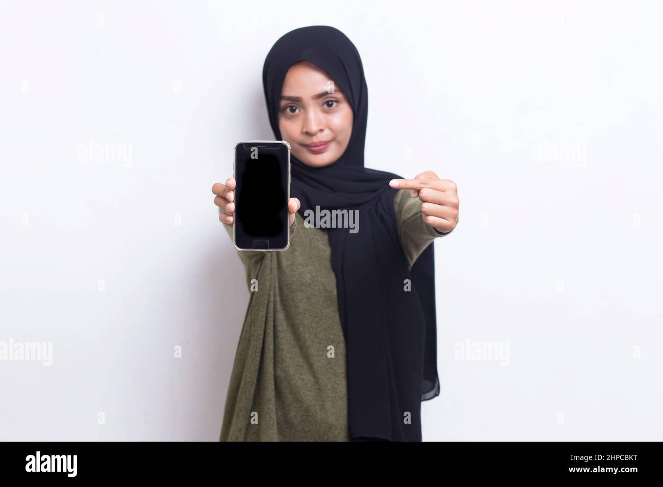 Happy Asian woman in hijab demonstrating mobile cell phone. Portrait of ...