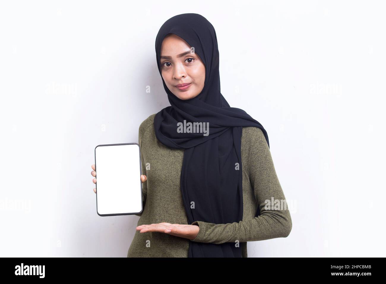 Happy Asian woman in hijab demonstrating mobile cell phone. Portrait of ...