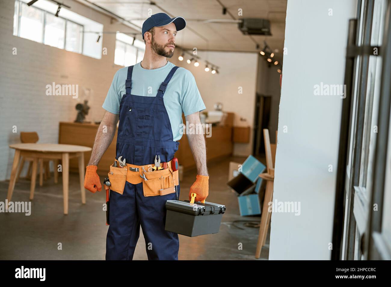 Male worker holding plastic box with tools Stock Photo