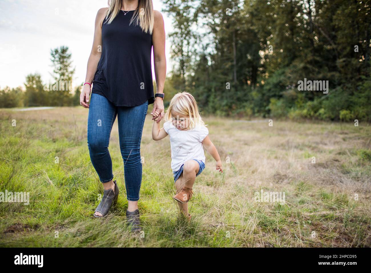 Patient mother holds hand of toddler girl during tantrum Stock Photo