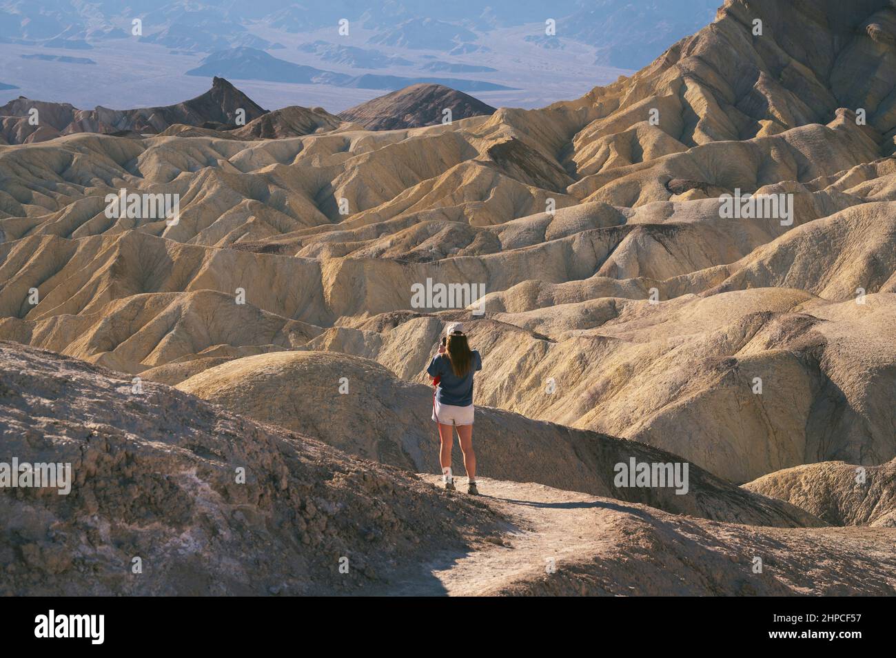 Female taking photo at Zabriskie Point in Death Valley National Park Stock Photo