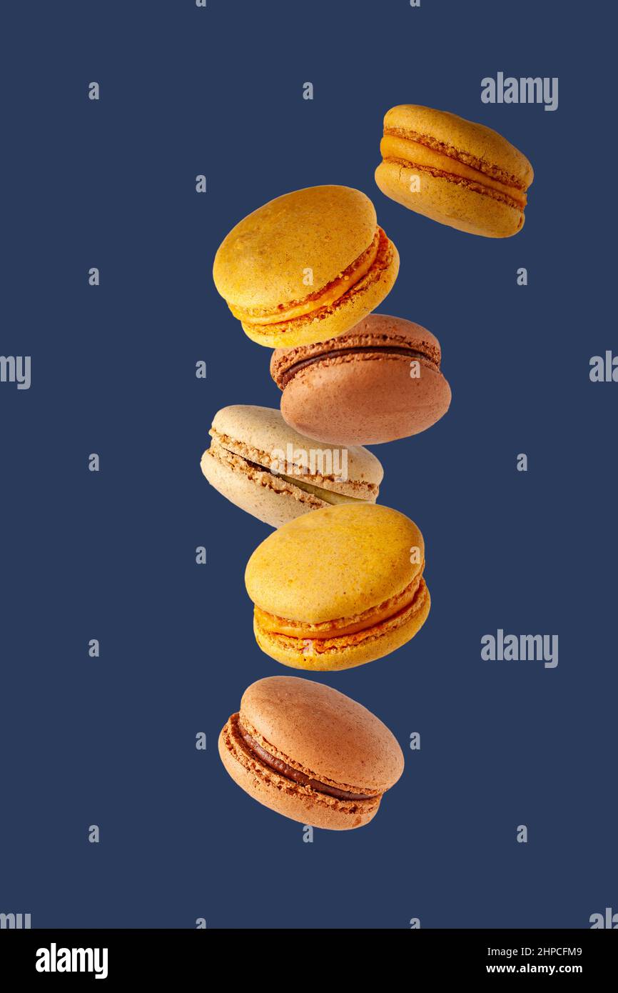 colored macaroons flying on a blue background Stock Photo