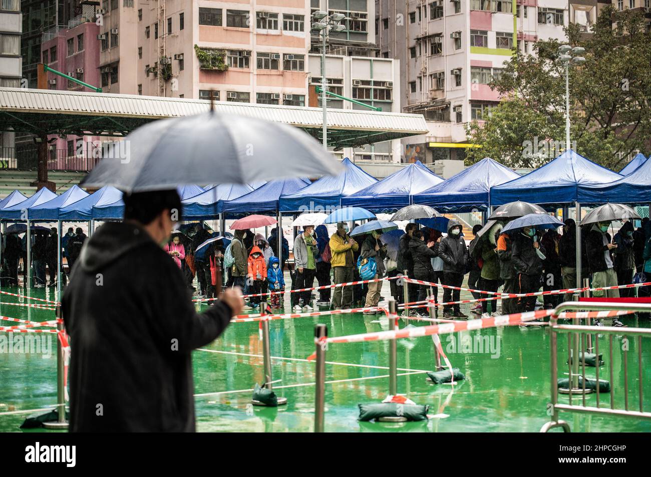 Hong Kong, Hong Kong. 20th Feb, 2022. Hong Kong residents queue in the rain to receive their COVID-19 tests. Hong Kong is well into the fifth wave of COVID-19 with the testing and health care systems overwhelmed due to thousands of new cases. Compulsory testing orders have been issued across the city, with hundreds of residents standing in the cold rain awaiting their turn. Credit: SOPA Images Limited/Alamy Live News Stock Photo