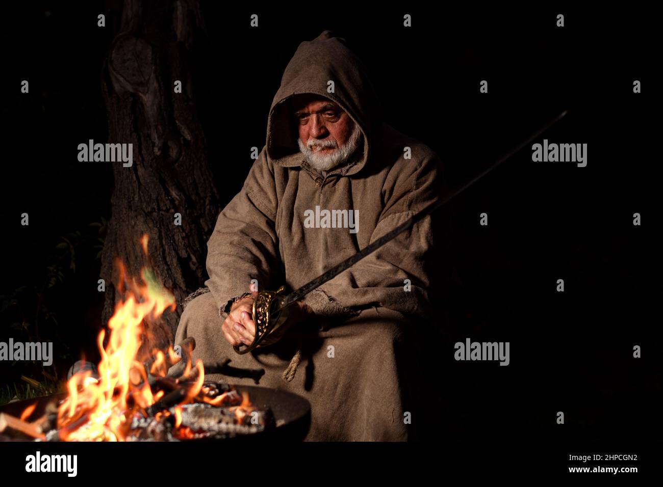 Templar with sword at the campfire Stock Photo