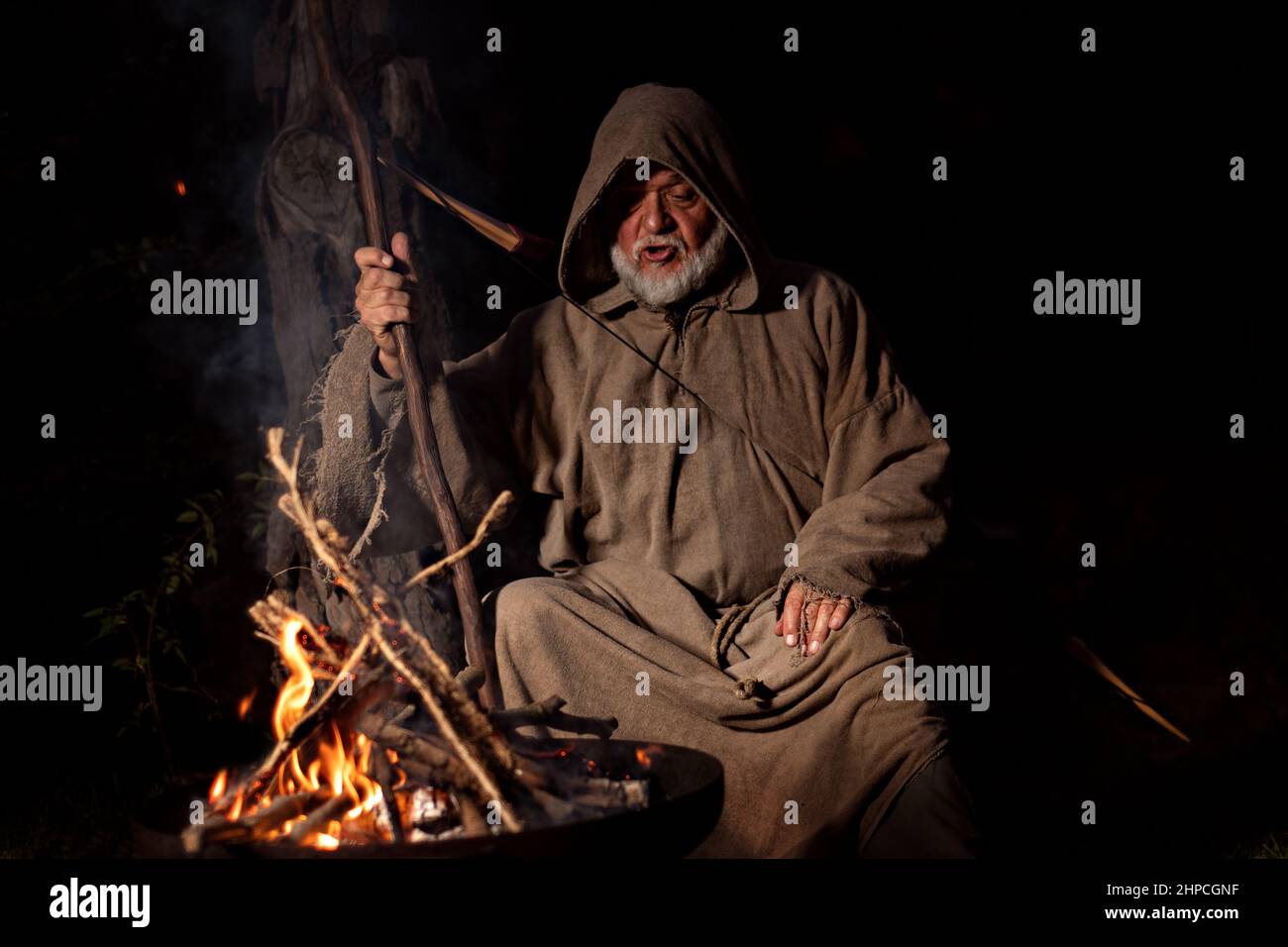 Monk in the Middle Ages sings around the campfire Stock Photo