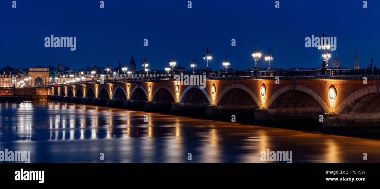 Panoramic view of stone bridge by night in Bordeaux, France Stock Photo