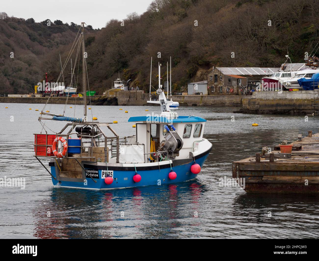 Small fishing boat docking at Polruan boatyard, Cornwall, UK Stock