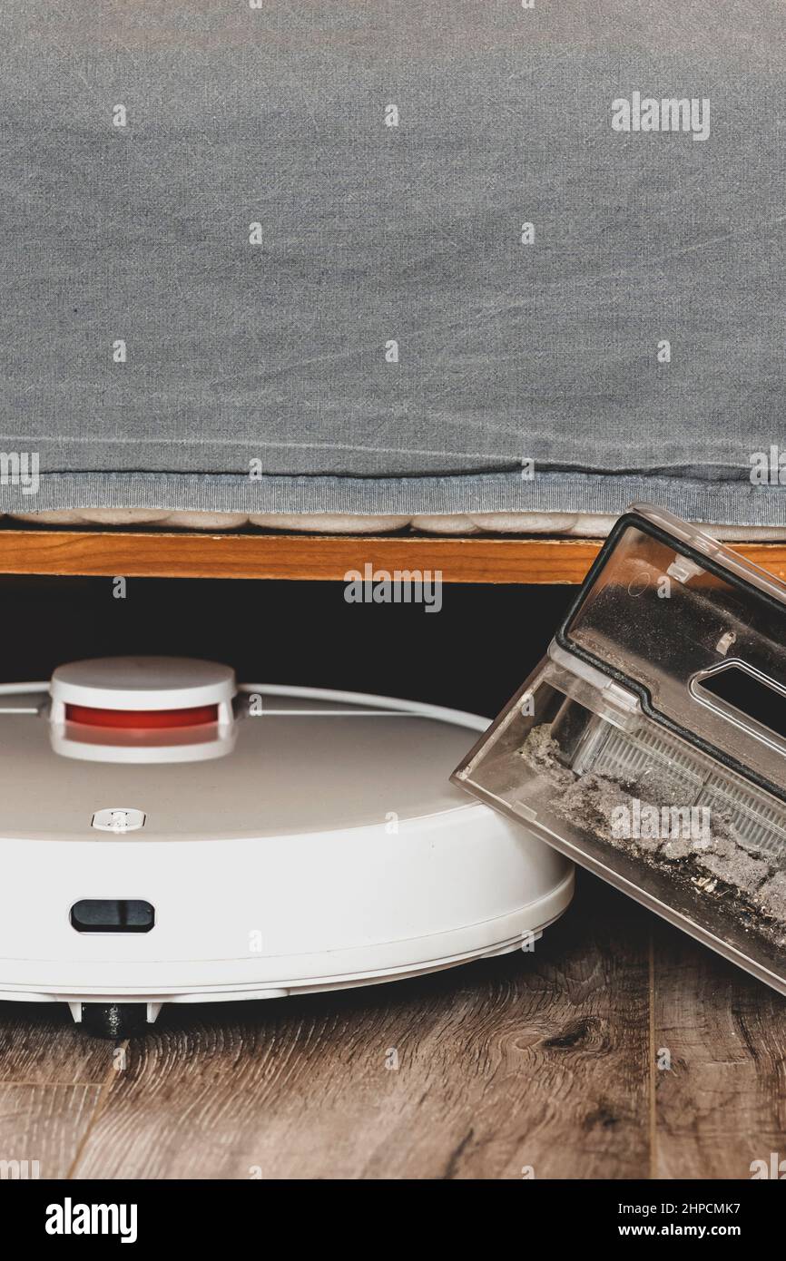 White robot vacuum cleaner.Garbage container. closeup. Robot vacuum