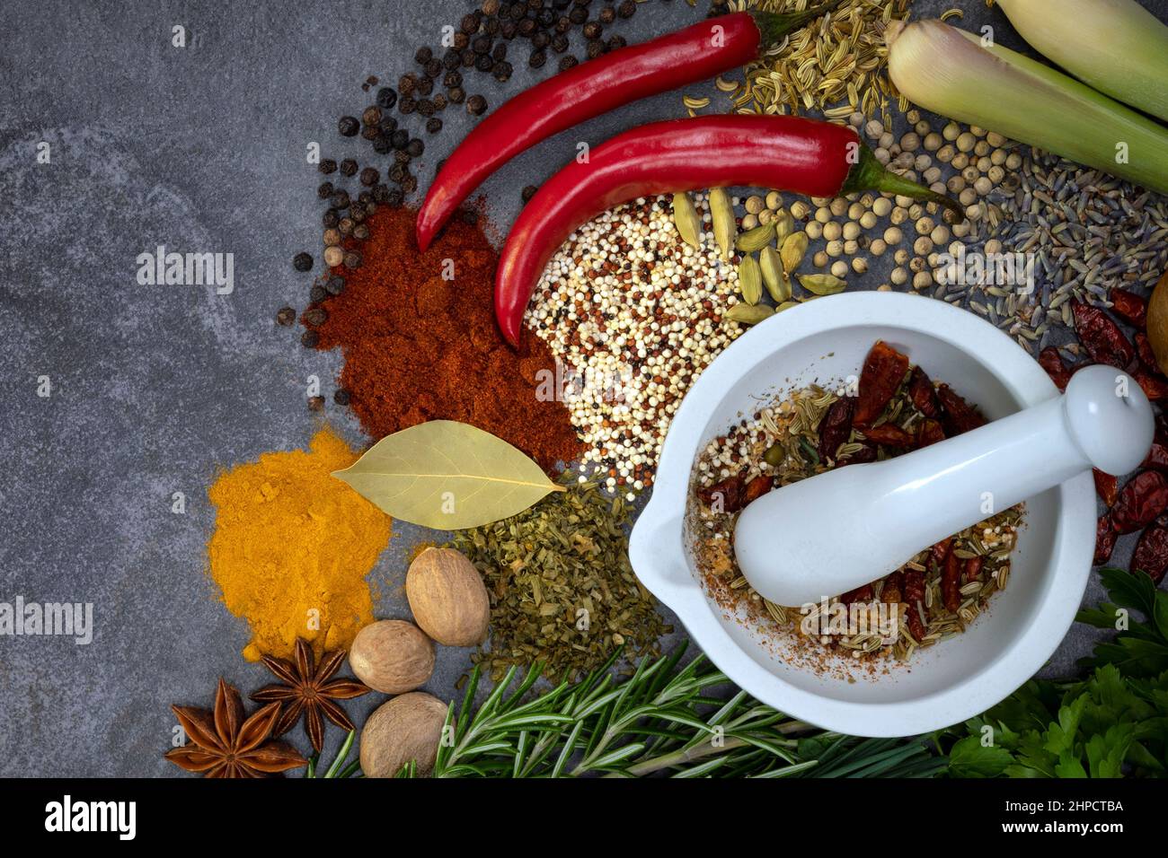 Herbs and Spices on a grey slate background with a mortar and pestle