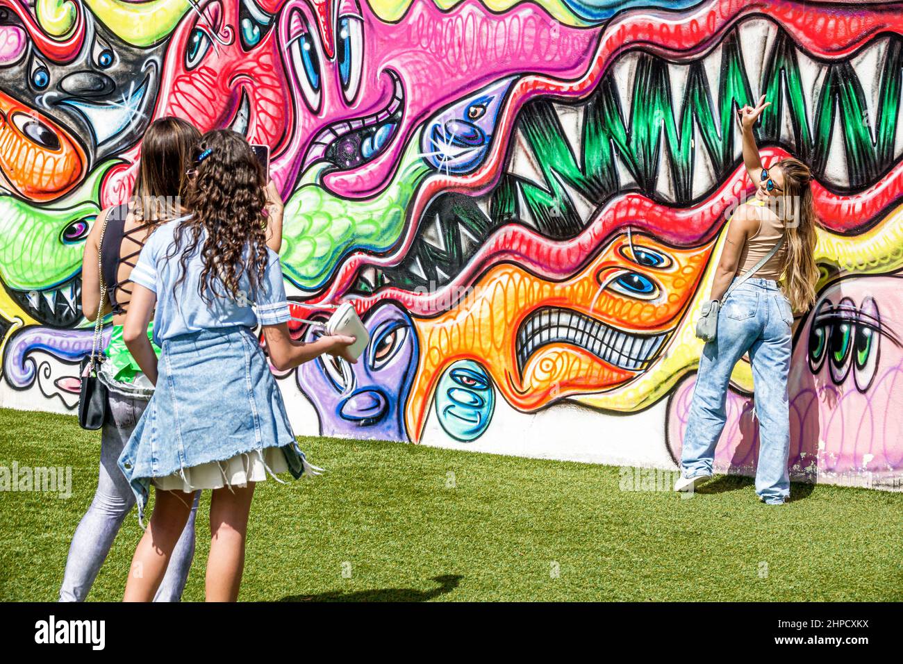 Miami Florida Wynwood Art District artwork wall visitors women friends posing teen teens girls girl teenagers Stock Photo
