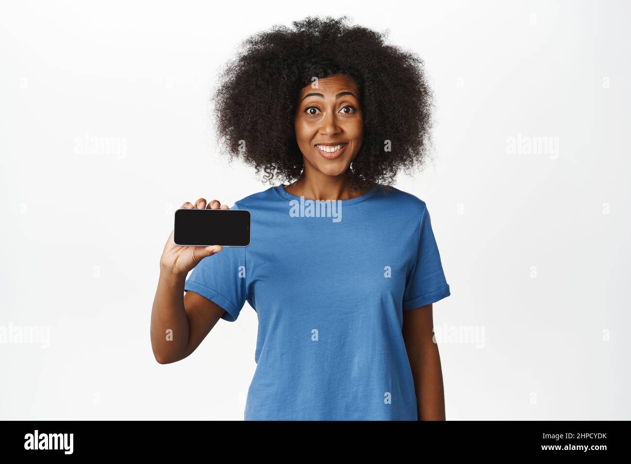 Cheerful african american woman showing horizontal smartphone screen ...