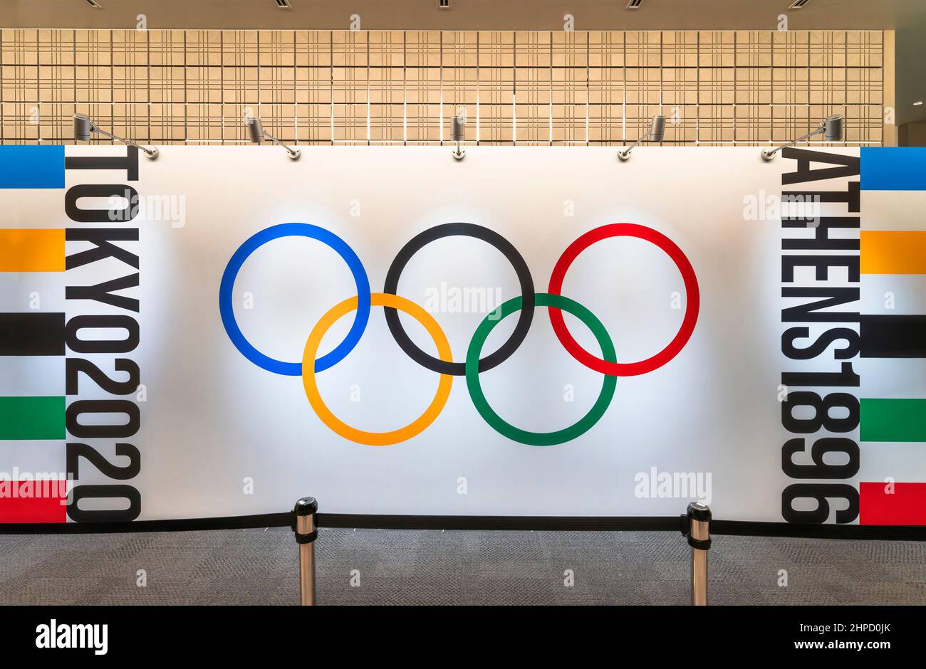 tokyo, japan - august 10 2021: Wallpaper depicting the official five olympic rings with words Athens 1896 and tokyo 2020 exhibited at olympic agora ex Stock Photo