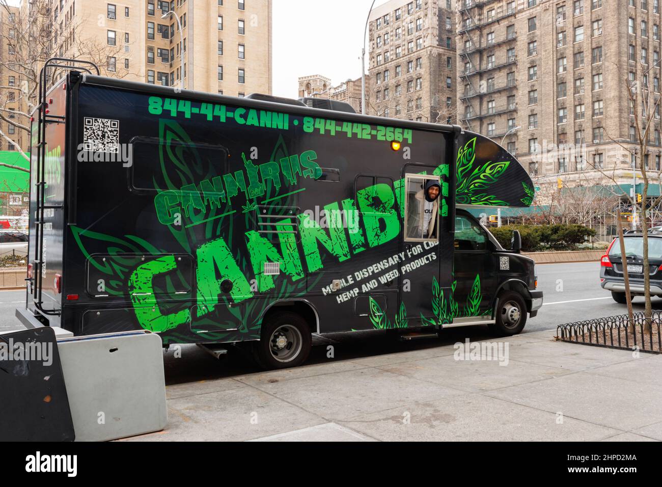 worker looks out the window of a Cannibus, a mobile dispensary for CBD, hemp, pot and marijuana products, parked on the Upper West Side of New York, a Stock Photo