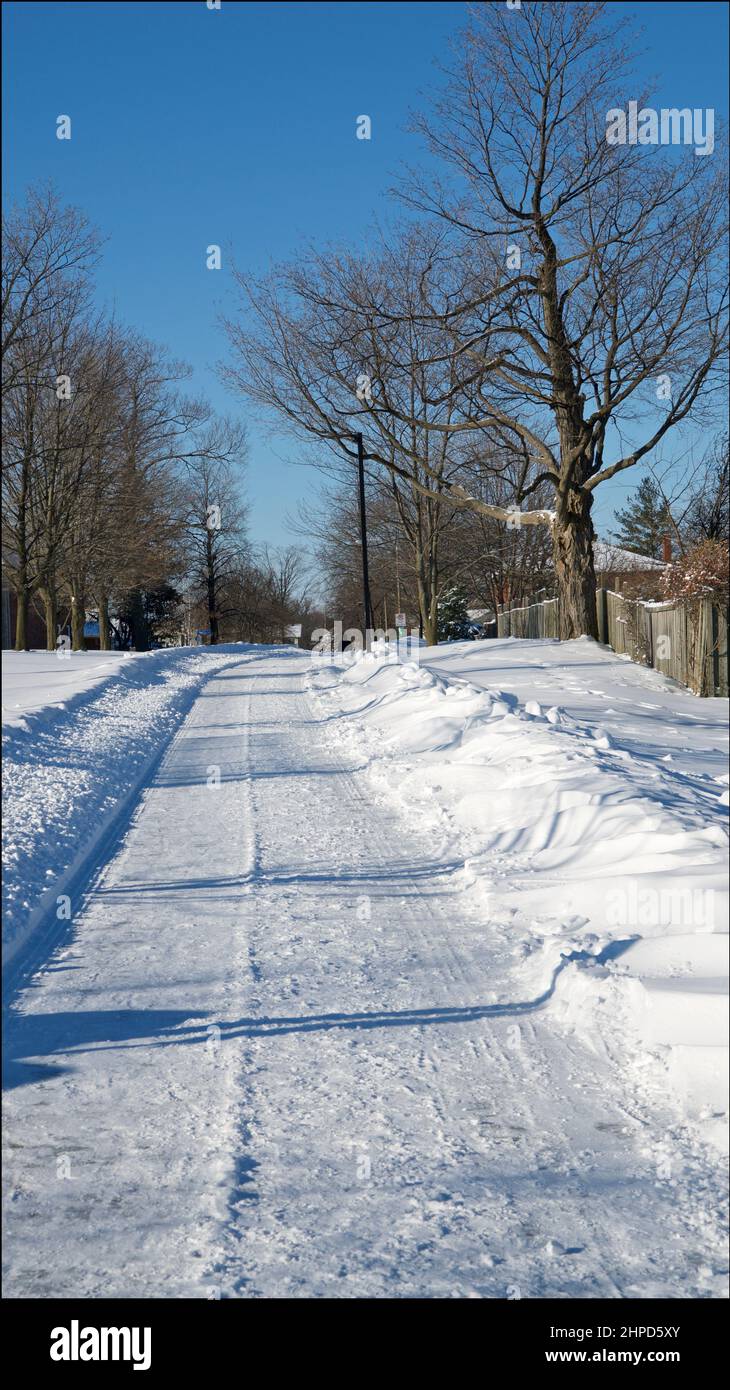 Footpath with deep snow for a winter weather concept. Vertical format background photos. Stock Photo