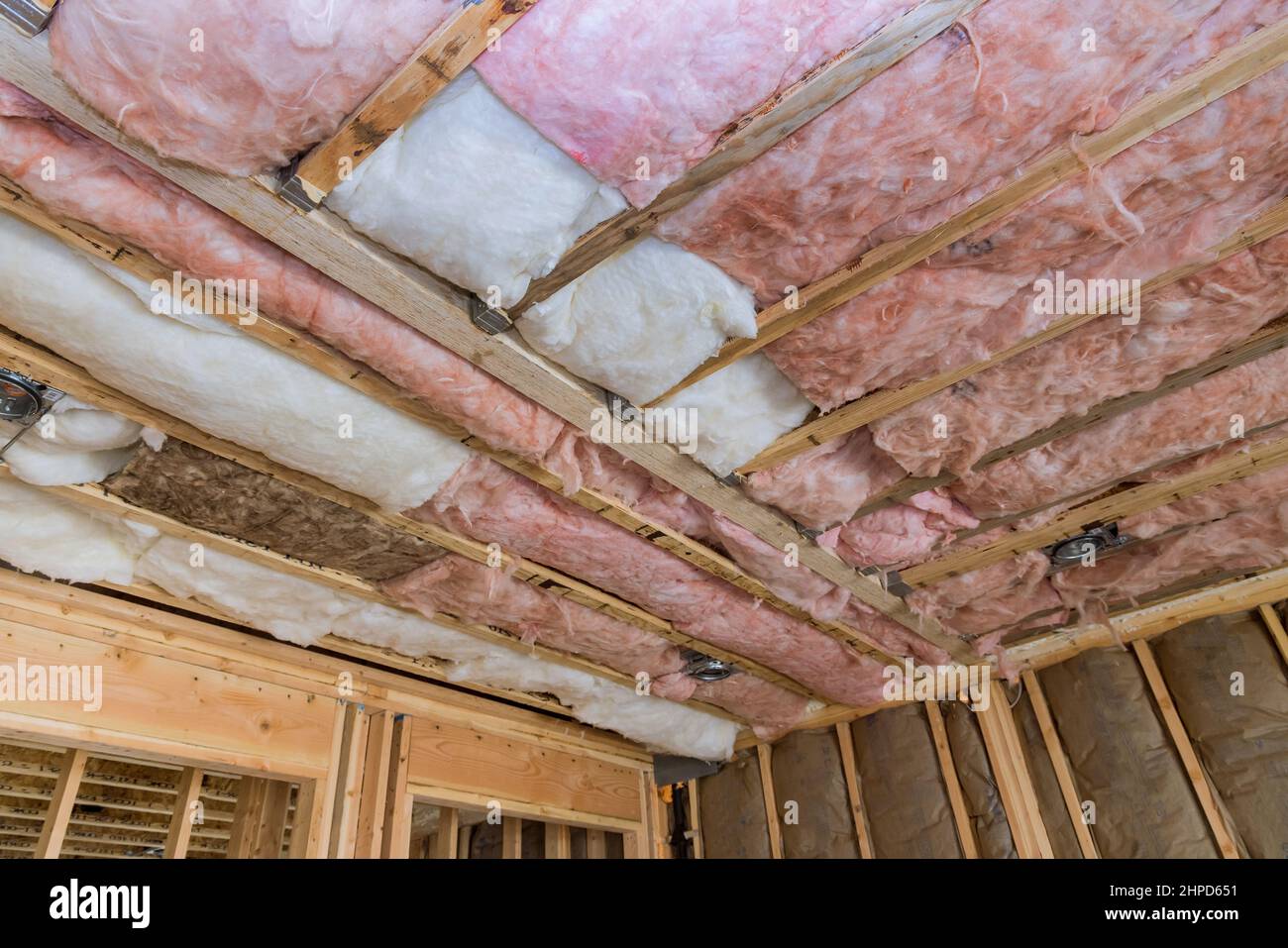 Mineral glass wool in a wooden frame on a inclined wall near the wooden ceiling a private house Stock Photo