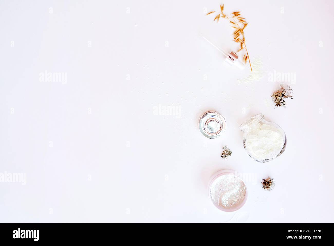 Dermatology cosmetics on white background. Trendy facecare cosmetics set. Alginate mask, serum droplet and patches. Natural forest moss and oat. Hyaluronic and moisturizing products. Copy space Stock Photo