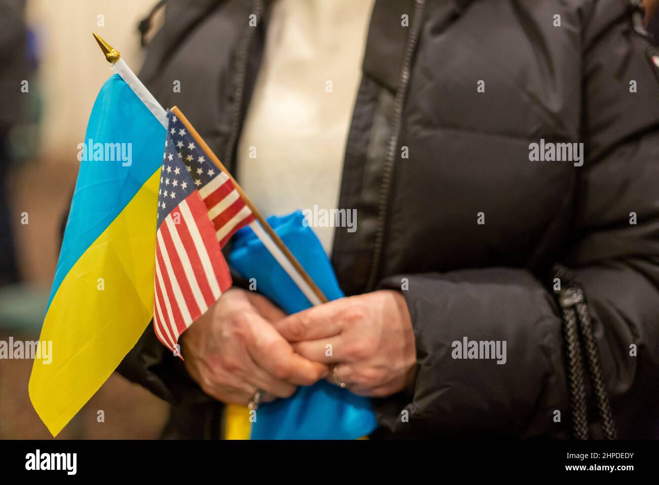 Warren, Michigan, USA. 20th Feb, 2022. The Ukrainian-American Crisis Response Committee holds a 'Stand with Ukraine' rally as residents fear the consequences of a possible Russian invasion of that country. Nearly 40,000 Michigan residents are of Ukranian descent.A woman help Ukrainian and American flags. Credit: Jim West/Alamy Live News Stock Photo