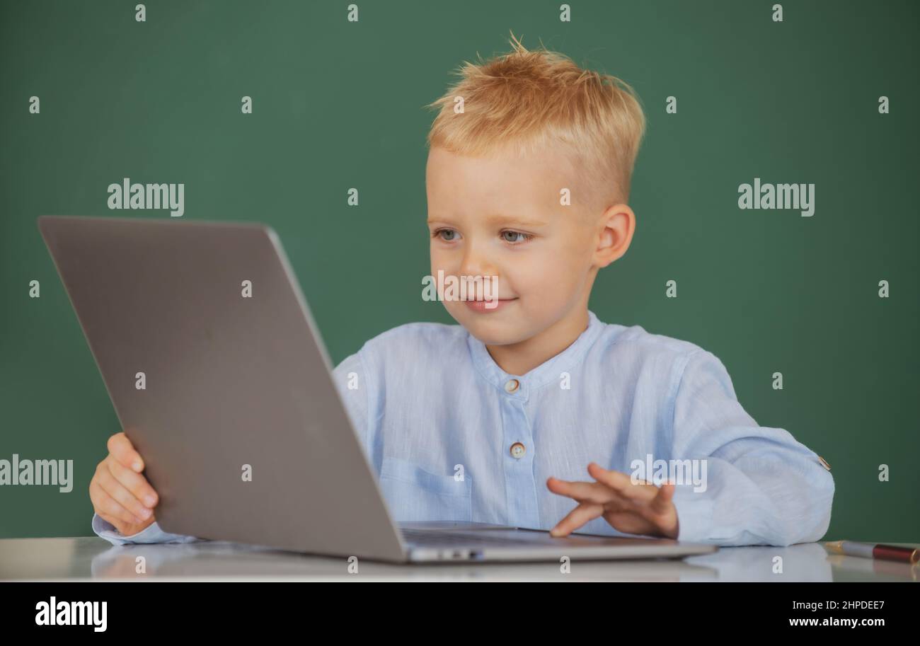 School boy learn lesson sitting at desk, studying online e-learning use internet. Genius child programming, computer training. Stock Photo