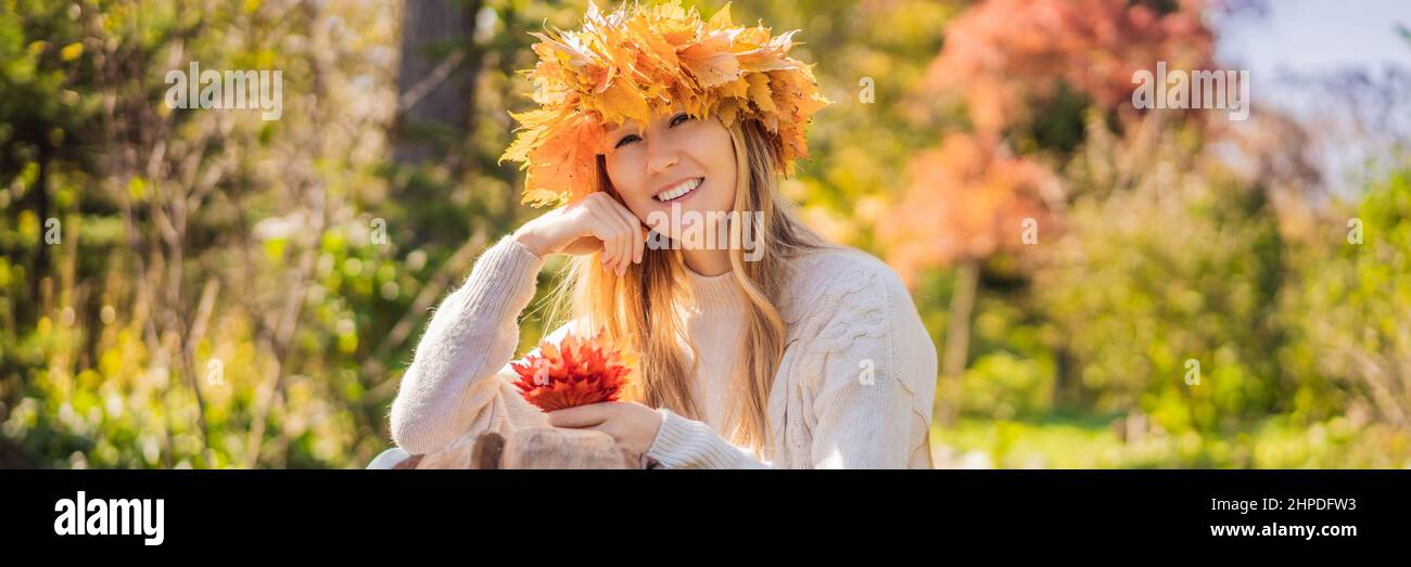 Outdoors lifestyle close up portrait of charming blonde young woman wearing a wreath of autumn leaves. Wearing stylish knitted pullover. Wreath of Stock Photo