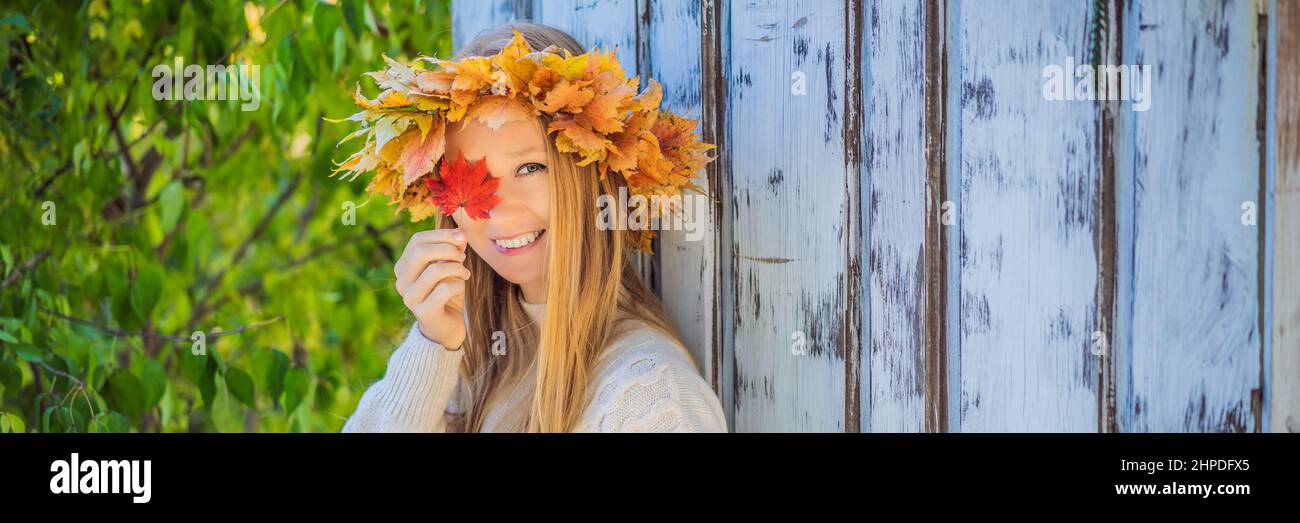Outdoors lifestyle close up portrait of charming blonde young woman wearing a wreath of autumn leaves. Wearing stylish knitted pullover. Wreath of Stock Photo