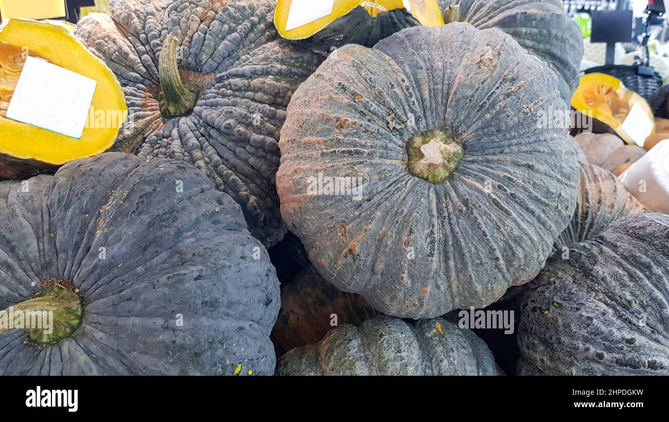 Several pumpkins were placed on the shelf. Some pumpkins were cut in half and had a white label attached to them. Stock Photo