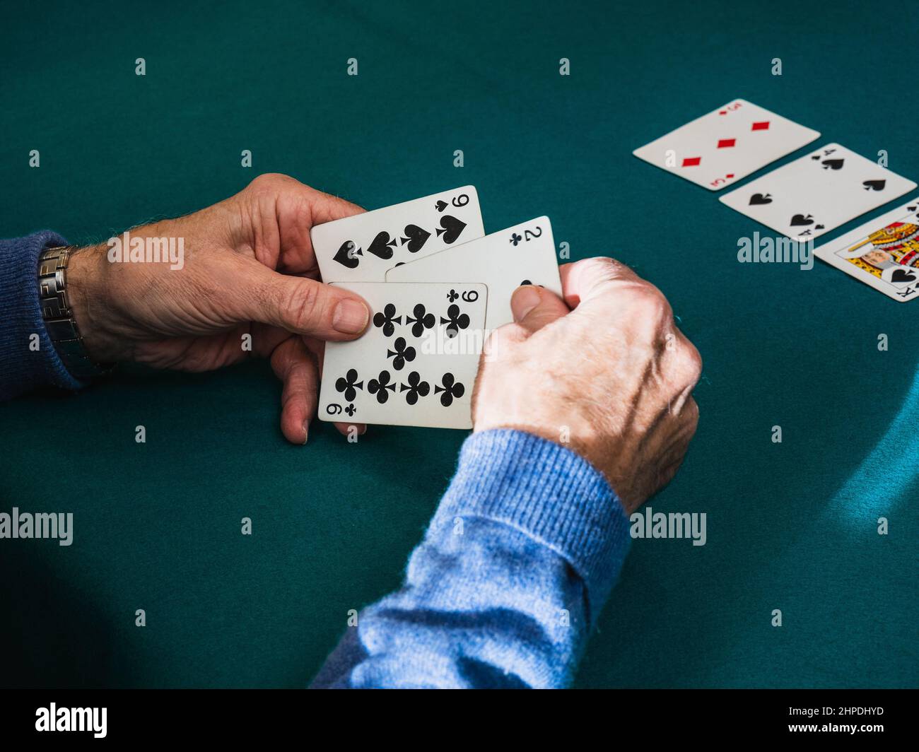 Old man hands playing cards in home Stock Photo