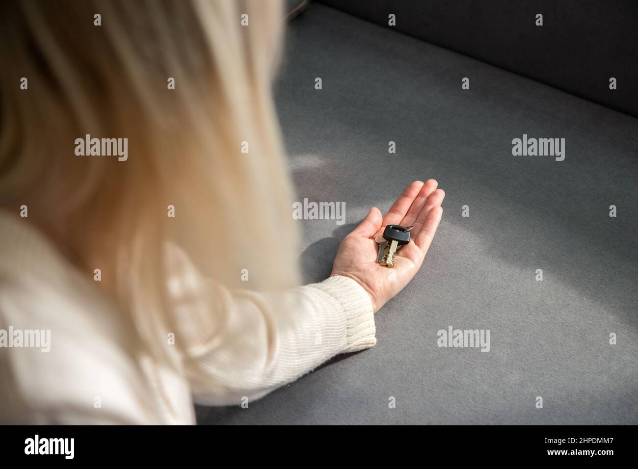 Young woman holding the keys to a new house in her palm. Moving to your ...