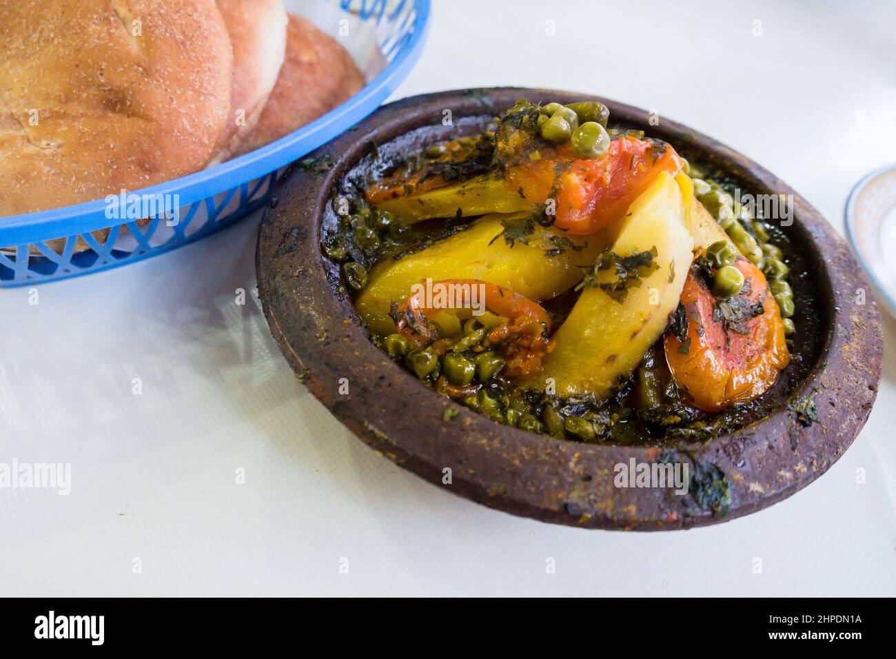 Traditional Moroccan tagine served with buns at a restaurant Stock