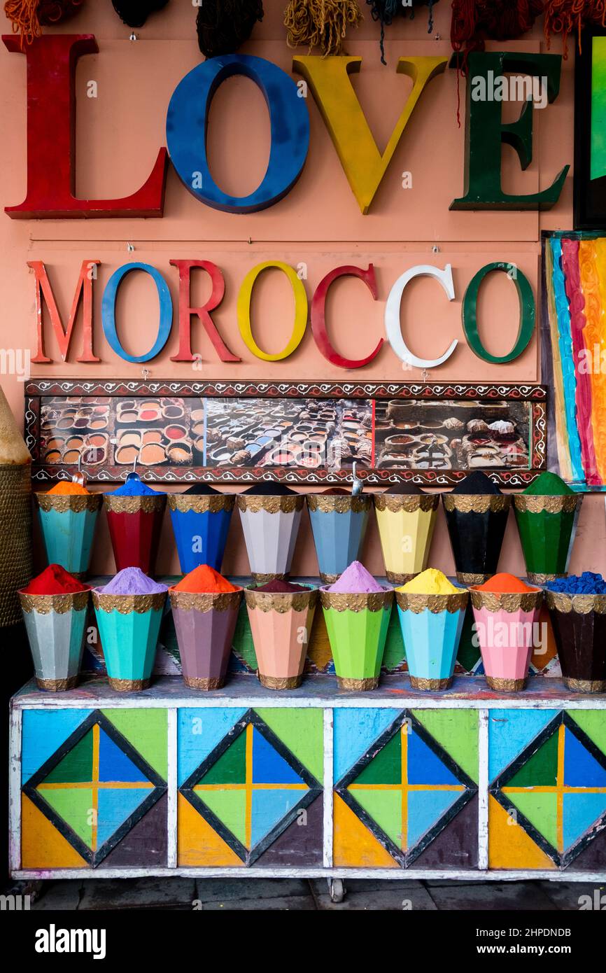 Love Morocco sign above containers filled with colourful dye powder in the Medina, Marrakech, Morocco Stock Photo