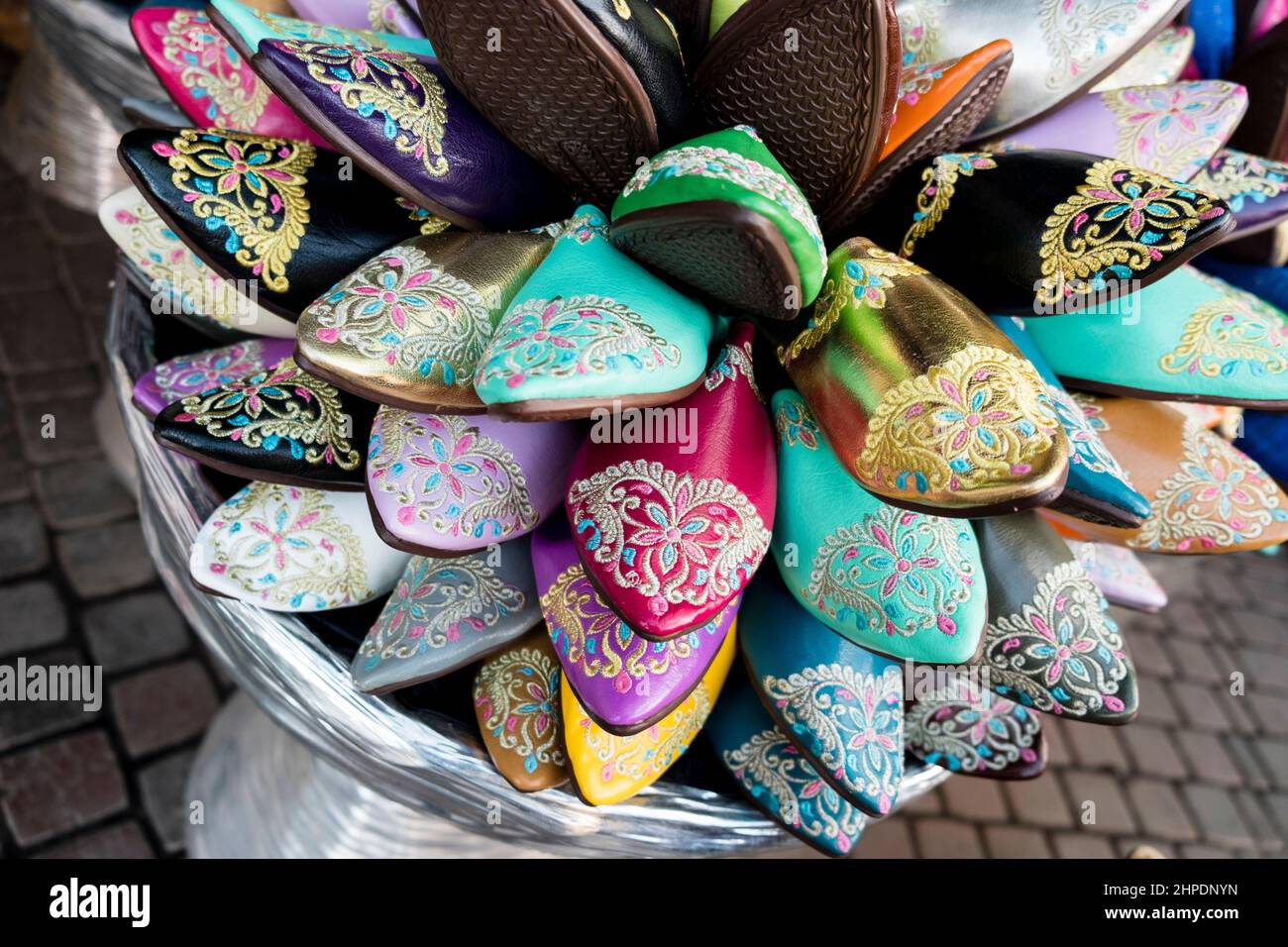 Colourful embroidered leather babouche shoes for sale at a souk in the Medina, Marrakech, Morocco Stock Photo