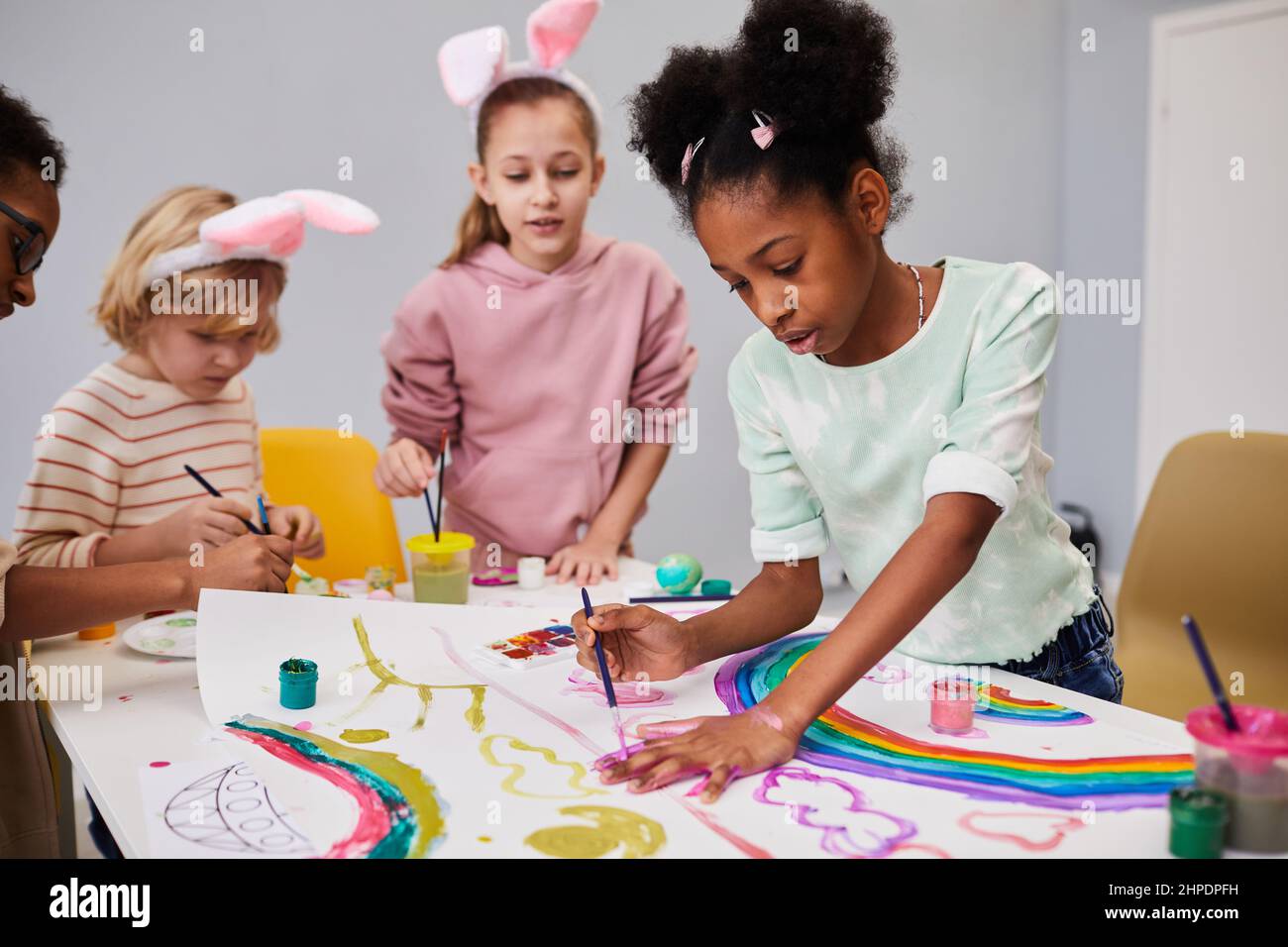Diverse group of kids at art and craft table on easter party for ...